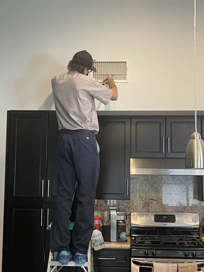 Technician inspecting an air vent during HVAC service in Rocklin